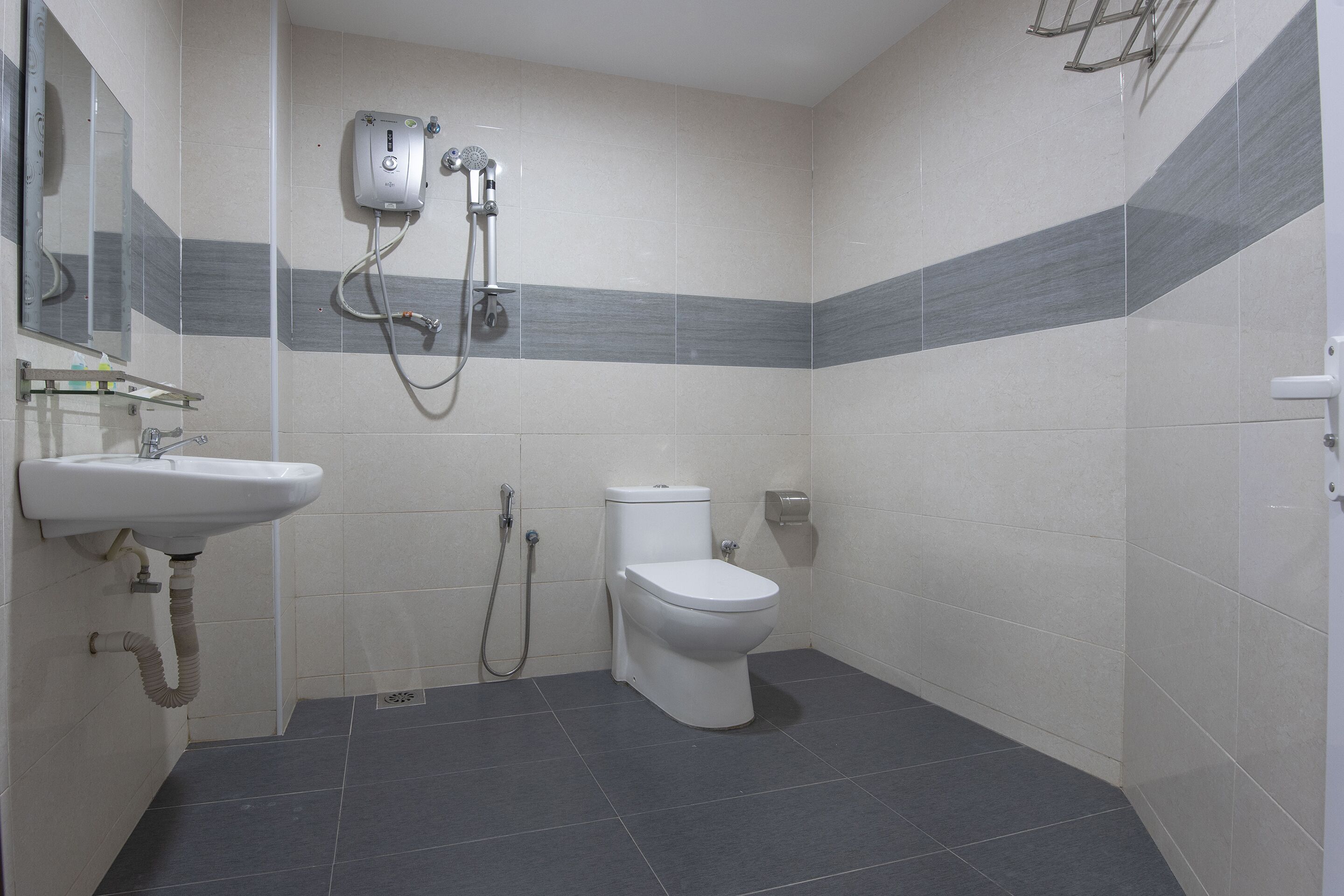 A bathroom with a toilet, sink, and shower unit.