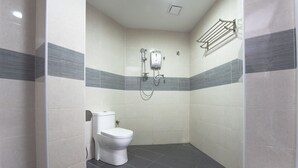 Ein kleines, modernes Badezimmer mit Toilette, Duschkabine und Handtuchhalter.