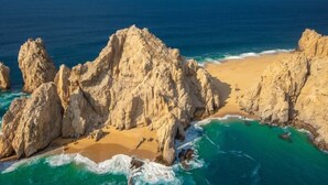 Un paisaje costero con formaciones rocosas y una playa de arena.