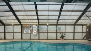 Una piscina interior con carriles claramente delimitados, un cartel de socorrista y un cartel que indica ausencia de socorrista.