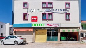 A hotel named "Hotel Bugambilia" with a red logo, a blue awning, and a closed yellow garage door. - OYO Hotel Bugambilia San Luis Potosi (San Luis Potosi)