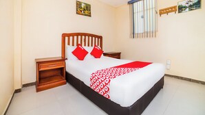 A neatly arranged bedroom with a wooden bed, a nightstand, a bedside table, and a window with bars. - OYO Hotel Bugambilia San Luis Potosi (San Luis Potosi)