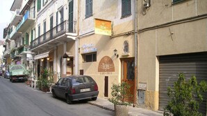 Une rue bordée de voitures garées et de plantes en pot.