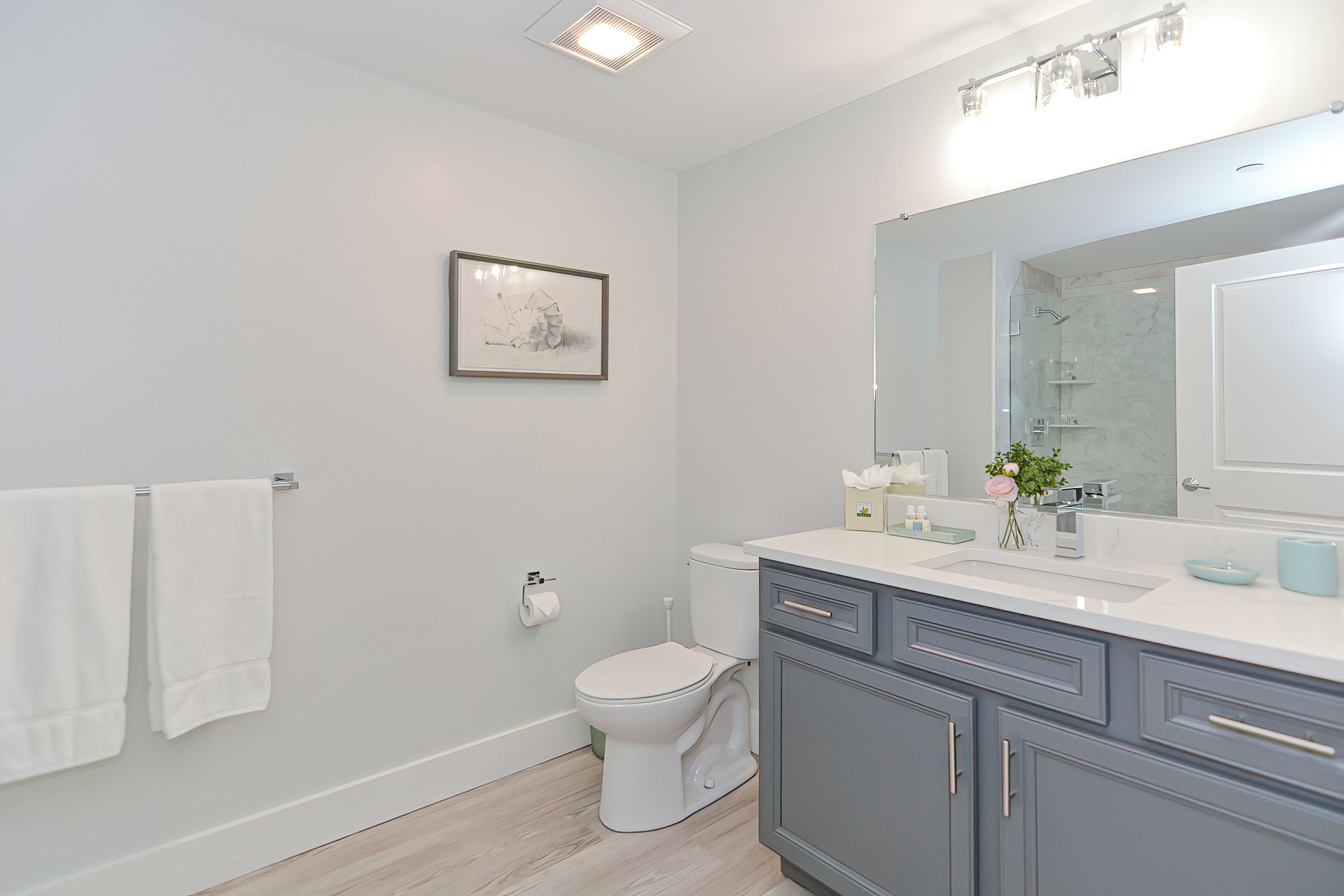 A modern bathroom with a toilet, sink, and mirror.