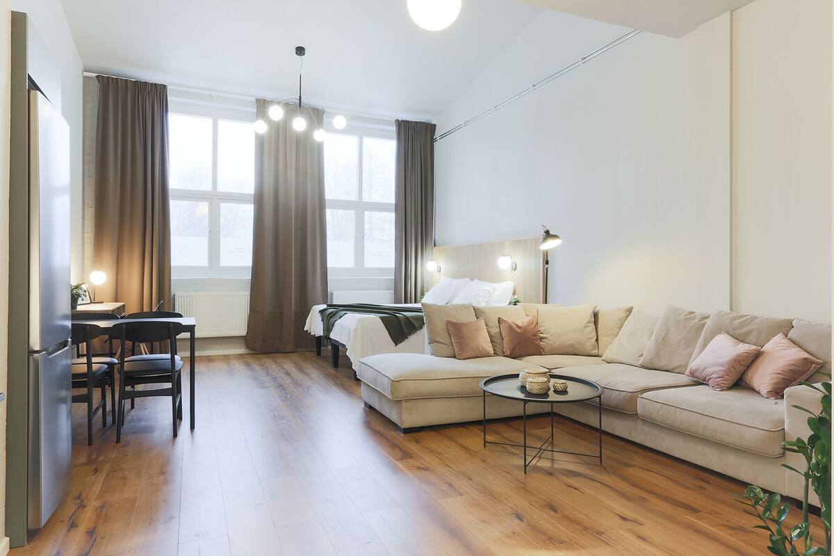 A modern living room with a sofa, coffee table, and dining area.