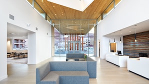 A spacious lobby with a modern design, featuring a large seating area, a reception desk, and large windows offering views of the surrounding area. - WorldMark Moab  (Moab)