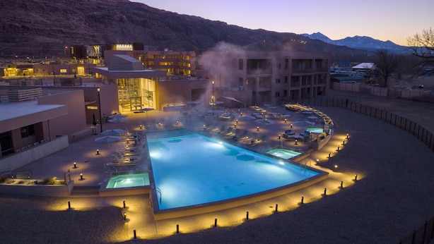 A resort with a large pool, lounge chairs, and a mountainous backdrop. - WorldMark Moab  (Moab)