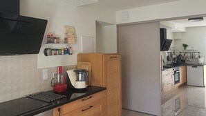 Et moderne køkken med indbyggede hårde hvidevarer, træskabe og en sort bordplade.