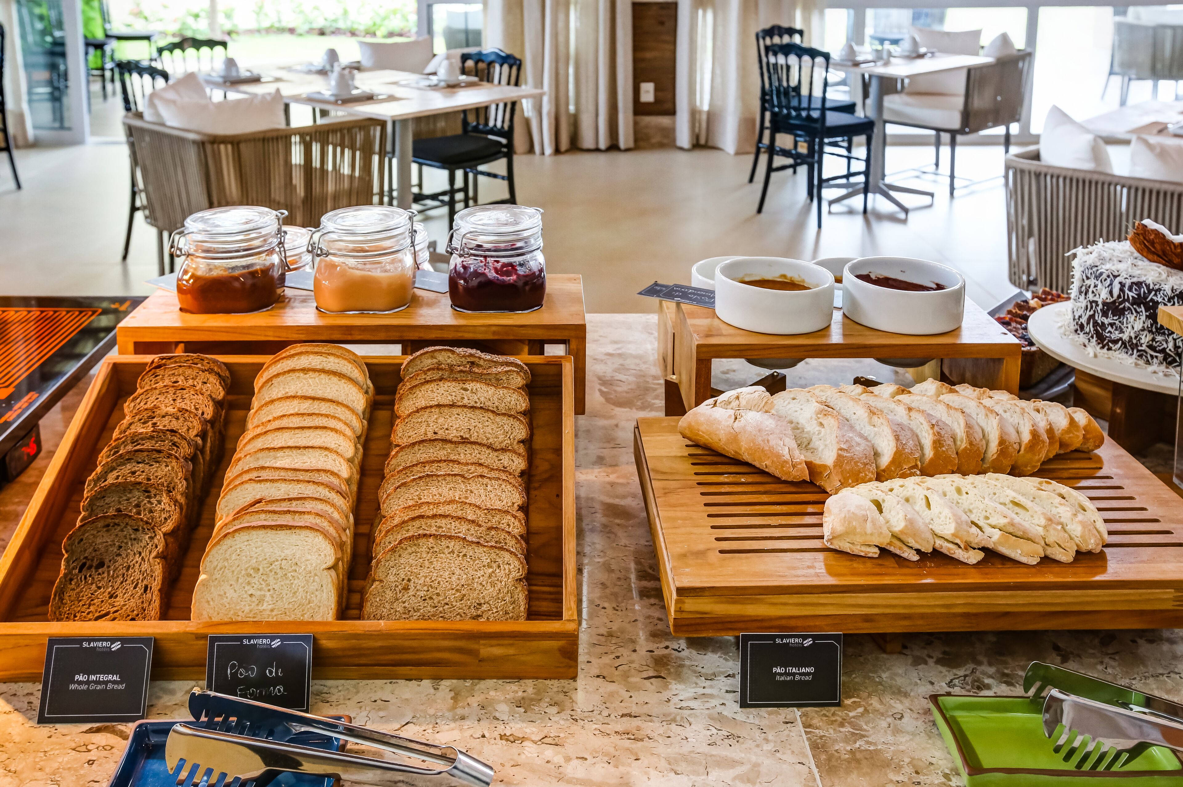 Un bufé de desayuno con panes, mermeladas y pasteles variados.