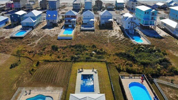 An aerial view of a coastal hotel with multiple buildings, each featuring a swimming pool.