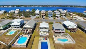 A coastal resort with multiple buildings, each featuring a swimming pool and a view of the ocean.