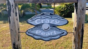 A wooden sign with the text "The Crazy Pearl" and the number "3817" above it.