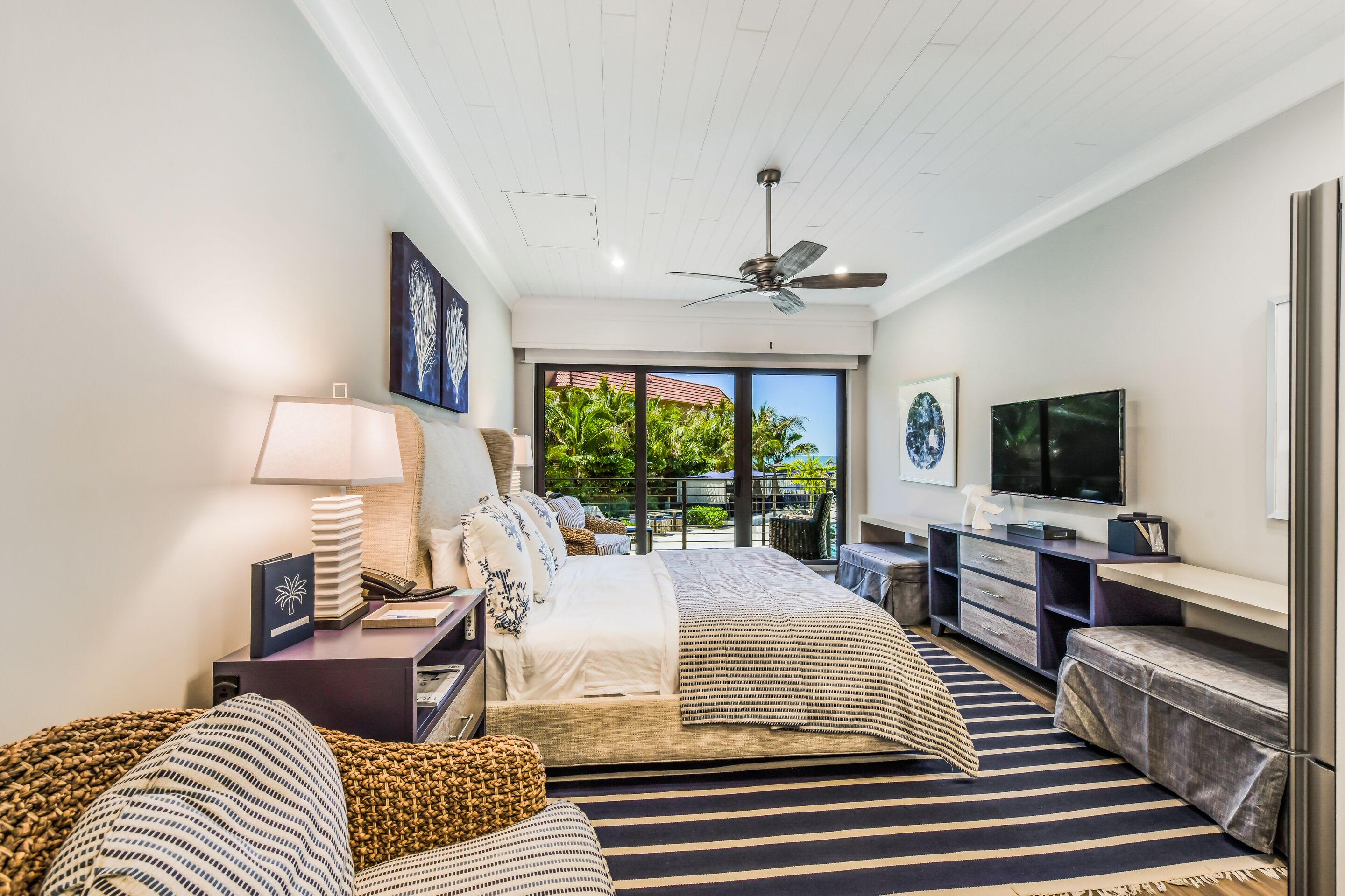 A modern bedroom with a bed, bedside table, lamp, and a TV.