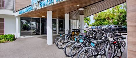 Un edificio con un cartel que dice 'Beach Resort' y una fila de bicicletas estacionadas afuera.