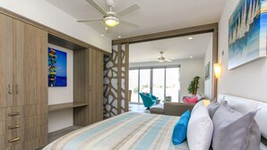 Un dormitorio moderno con una cama grande, un ventilador de techo y vistas al exterior.