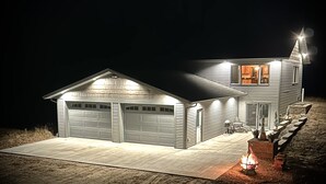 A two-story house with a garage and a fire pit in the front yard. - Gracie- A spacious house near Swan Lake! (Pengilly)