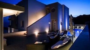 Zona de piscina exterior moderna amb gandules i una escala que condueix a un nivell superior.