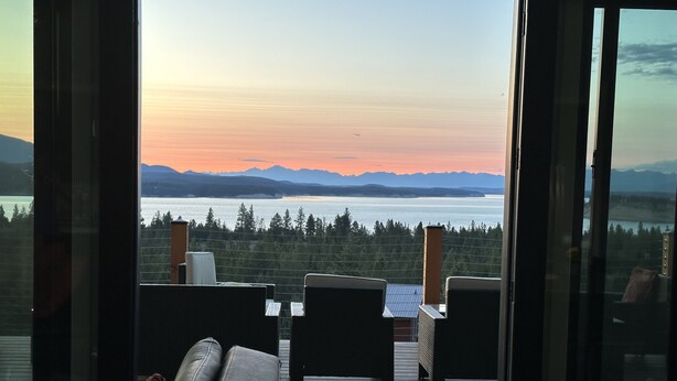 Ein modernes Wohnzimmer mit Seeblick und Bergbachgrund.
