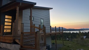 Eine Holzhütte mit einer Holzterrasse und Blick auf die Berge.