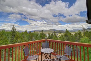 A wooden deck with a table and chairs overlooking a mountainous landscape. - Secluded and peaceful townhome w/ hot tub and amazing views of Lake Dillon (Frisco)