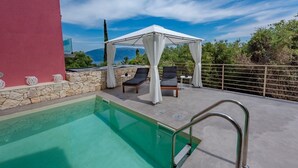 A rooftop pool with a stone wall, a white canopy, and two lounge chairs. - Villa Elizabeth with pool close to Fiskardo (Fiskardo)