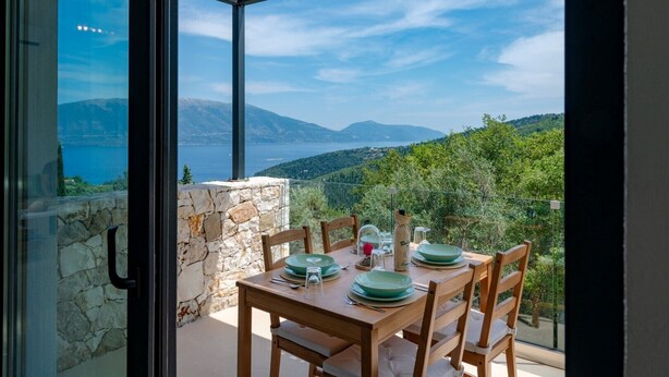 A dining table set for four with a view of a lake and mountains. - Villa Elizabeth with pool close to Fiskardo (Fiskardo)