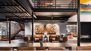 Un intérieur moderne comprenant un coin repas, des sièges et un escalier.