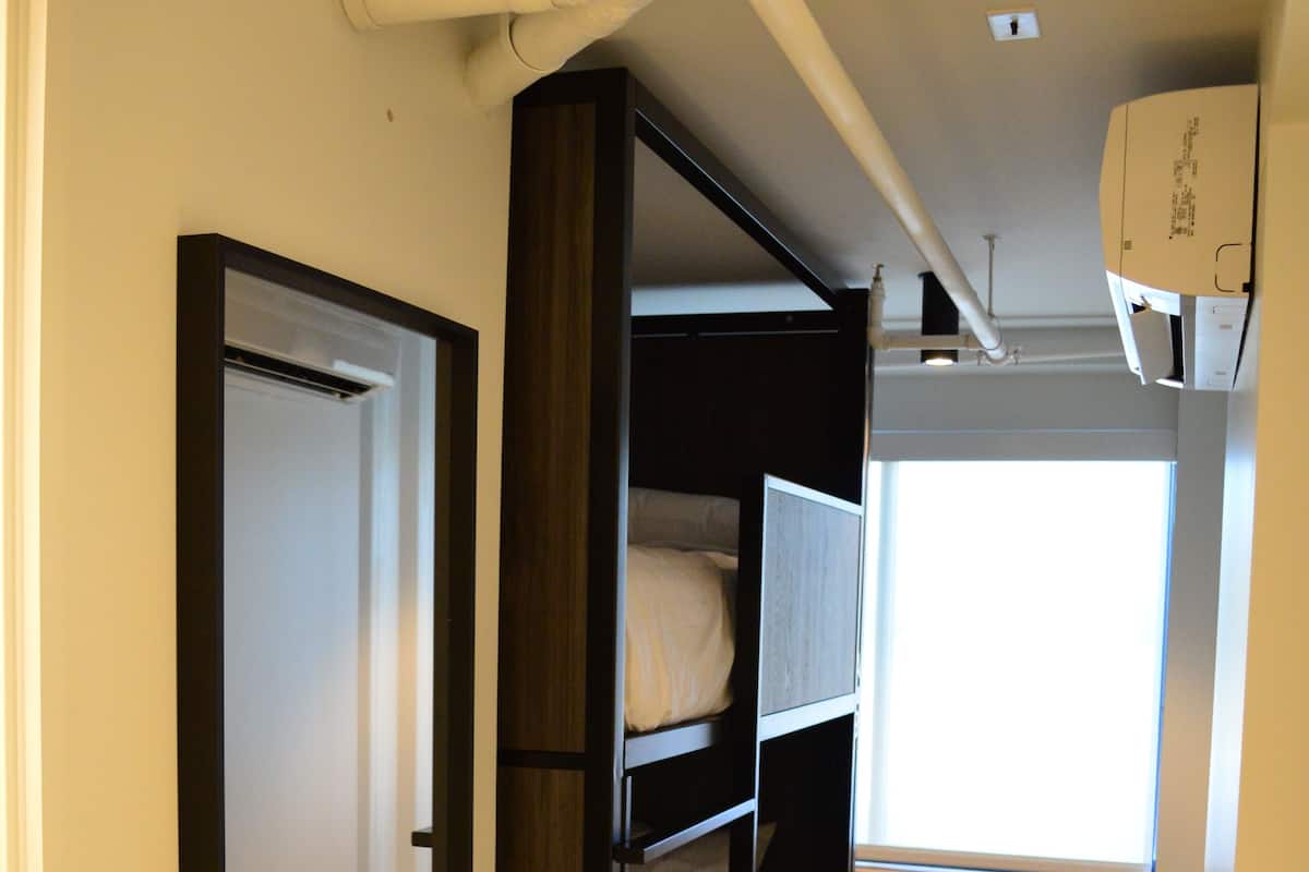 Una habitación con literas, una ventana y un radiador.
