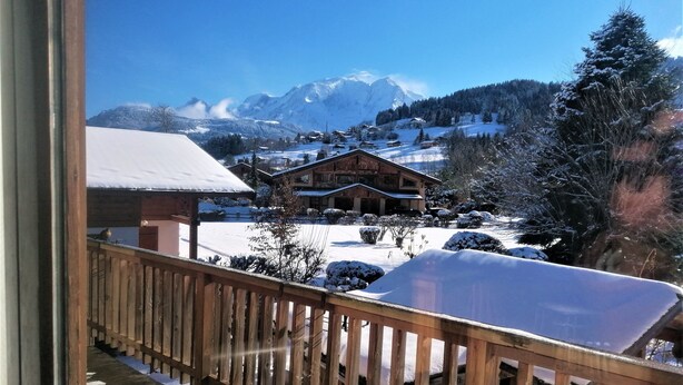 A wooden balcony with a view of a snow-covered mountain and a lodge. - jlulbert's chalet near biotop lake and center (Combloux)