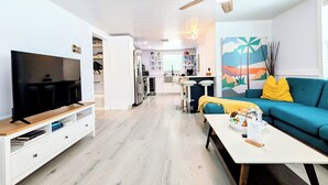 Een moderne woonkamer met een televisie, bank en salontafel.