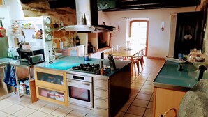 Una cuina amb una illa central, forn de foc, microones i diversos electrodomèstics.