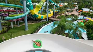 A water park with multiple slides and pools, surrounded by greenery.