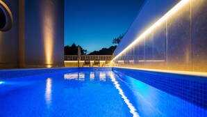 Une piscine offrant une vue dégagée sur le ciel et sur un bâtiment situé au loin.