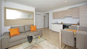 Un appartement moderne comprenant un espace de vie, une cuisine et un coin repas.