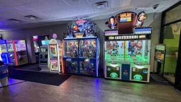 A row of arcade machines with various themes, including Marvel Avengers and NFLPA Super Star Football Coins.