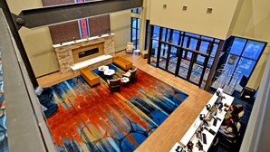 A spacious living area with a fireplace, comfortable seating, and a large window offering a view. - 7Clans Hotel & Resort (Newkirk)