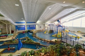 An indoor water park with multiple pools, slides, and play structures. - 7Clans Hotel & Resort (Newkirk)