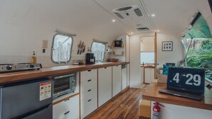 Una cocina compacta con estufa, horno y una computadora portátil sobre la encimera.