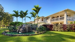 A two-story house with a balcony, surrounded by lush greenery and a small waterfall feature. - Paradise! Plantation at Princeville 3 Bed 3 Bath Condo (Princeville)