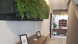 Ein Empfangsschalter mit gerahmten Willkommensschildern, einem QR-Code und einem Blumentopf.