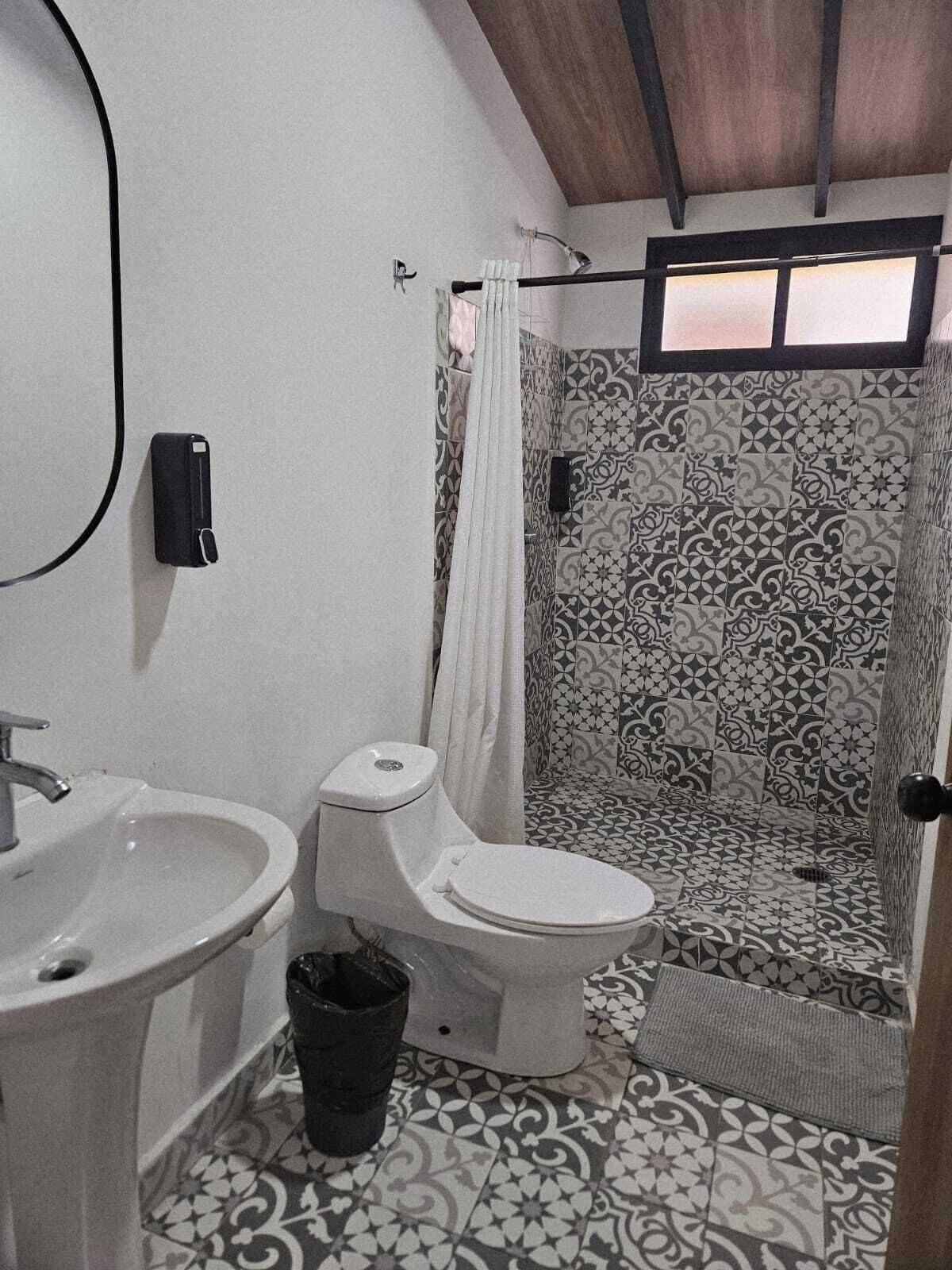 Ein Badezimmer mit Toilette, Waschbecken und Duschbereich.