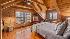 A cozy attic bedroom with a wooden ceiling, a bed, a dresser, and a window. - Eagle’s Crest at Mentone-Amazing Views, sleeps 8 (Mentone)