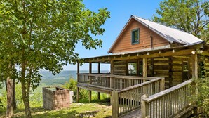 Una cabaña con terraza de madera y vista al paisaje.