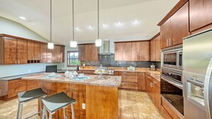 Una cocina moderna con armarios de madera, electrodomésticos de acero inoxidable y encimera de granito.