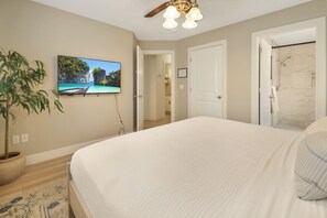 A bedroom with a large bed, a ceiling fan, a TV on the wall, and a potted plant. - Cozy Clean Home Near Zion - High Speed Internet - Self Check-In/Out (La Verkin)
