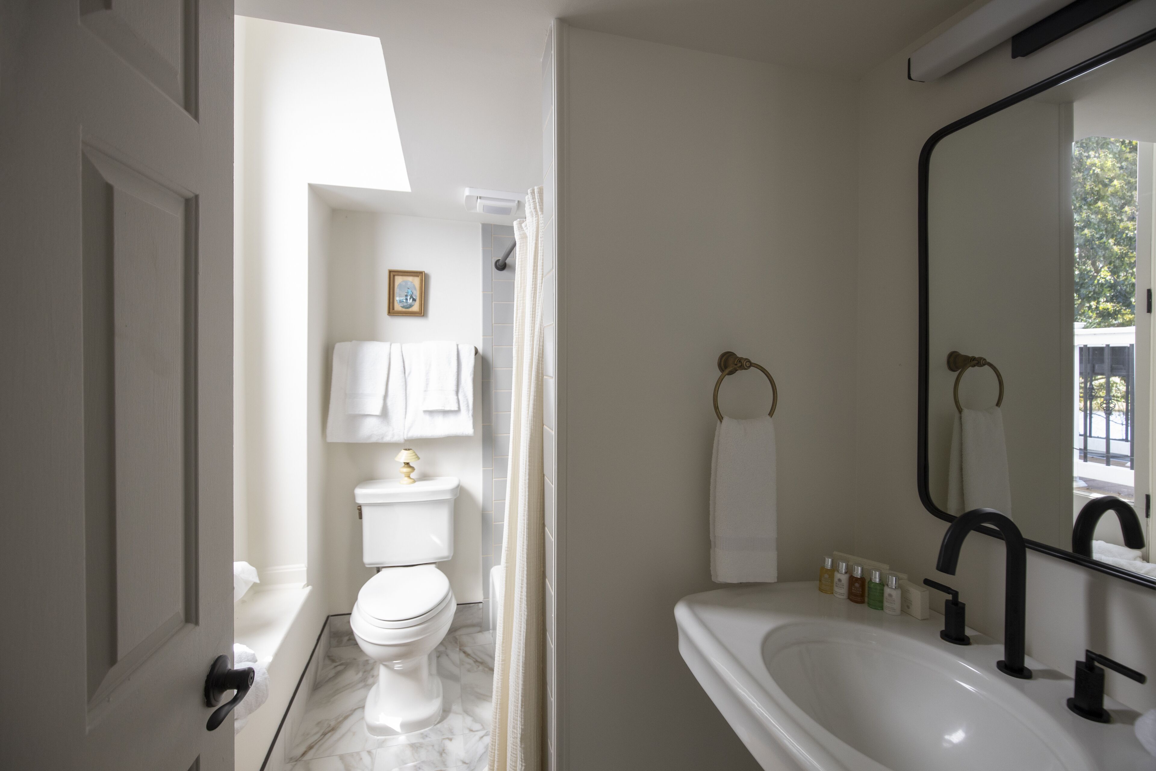 A bathroom with a toilet, sink, and shower.