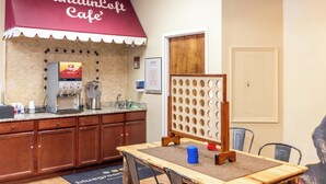 A kitchen area with a coffee machine, a wooden table with a mat, and a partition with circular cutouts. - MountainLoft™ - 2 Bedroom Combined Lodge (Gatlinburg)