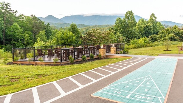 A deck with outdoor seating, a shuffleboard court, and a view of mountains. - MountainLoft™ - 2 Bedroom Combined Lodge (Gatlinburg)