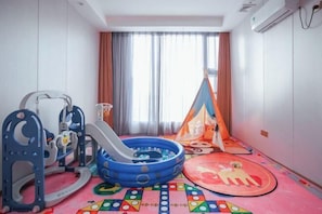 A children's play area with a slide, inflatable pool, and a tent.