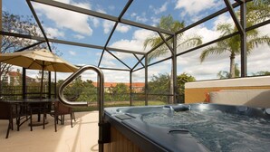 A hot tub area with a pergola structure, outdoor seating, and a view of palm trees and a distant building. - 3BR Townhouse with New Hot Tub - Near Disney! (Kissimmee)